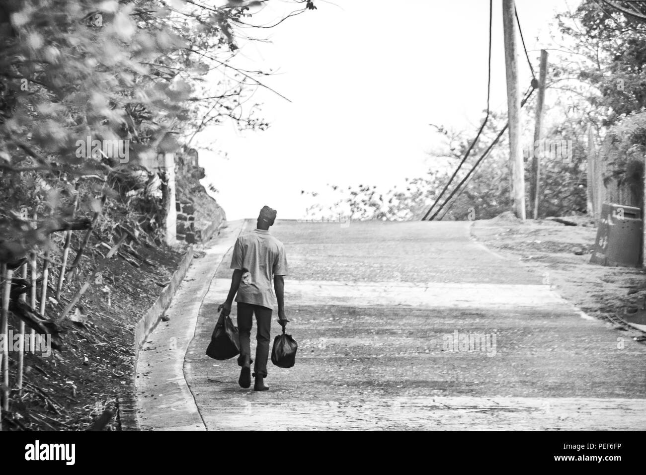 Uomo a camminare lungo una strada sull isola di Carriacou, Grenada Foto Stock