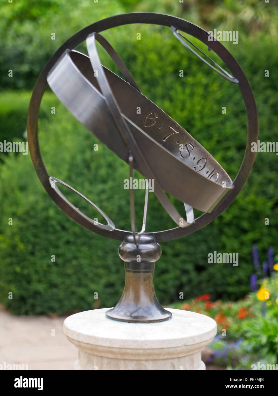Decorativa sfera armillare globo scultura di metallo. Messa a fuoco selettiva. I numeri sono stampigliati all'interno del nastro metallico. Foto Stock