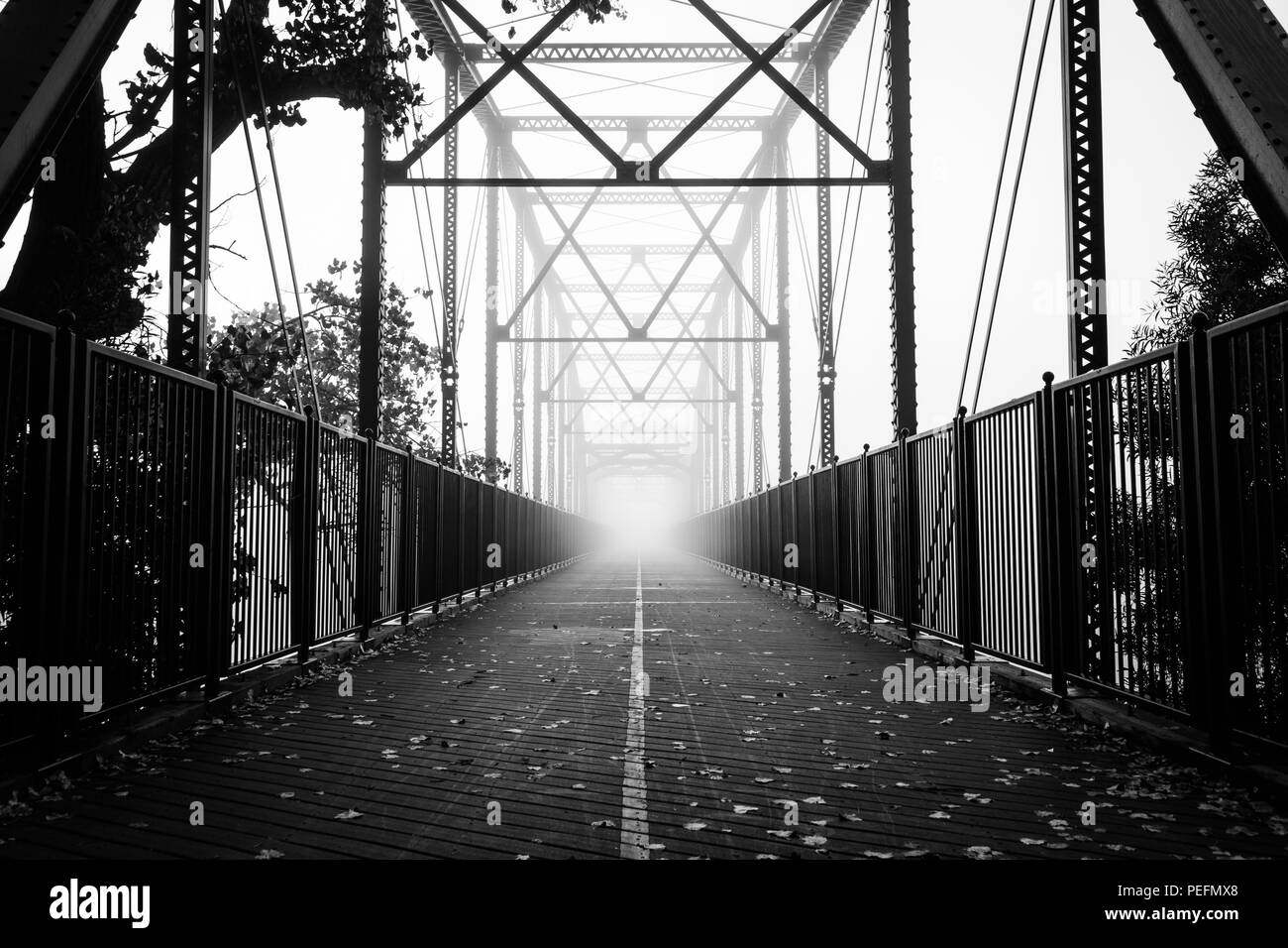Una fitta nebbia inizia a laminazione al vecchio Fair Oaks ponte sopra il fiume americano di Fair Oaks, California. Foto Stock