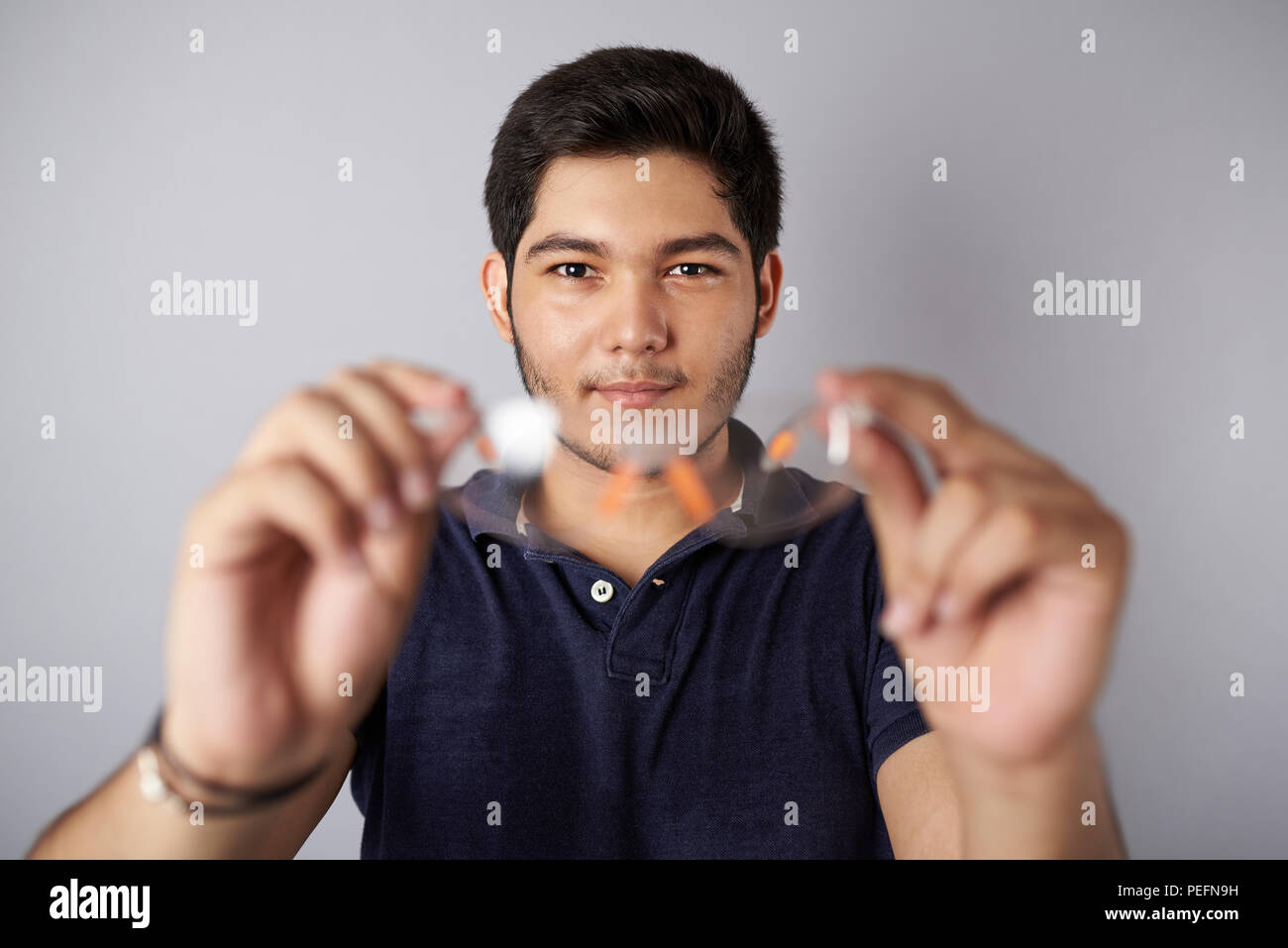 Mettere gli occhiali di protezione. Man tenere bicchieri in mani sfocato Foto Stock