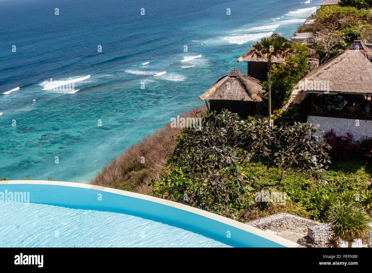Case e la piscina a sfioro con vista oceano sulla rupe sopra il Karma Beach in Ungasan, Bali, Indonesia. Foto Stock