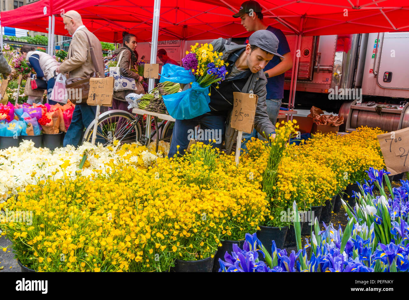 Persone che acquistano i fiori in un mercato di strada nella città di New York Foto Stock