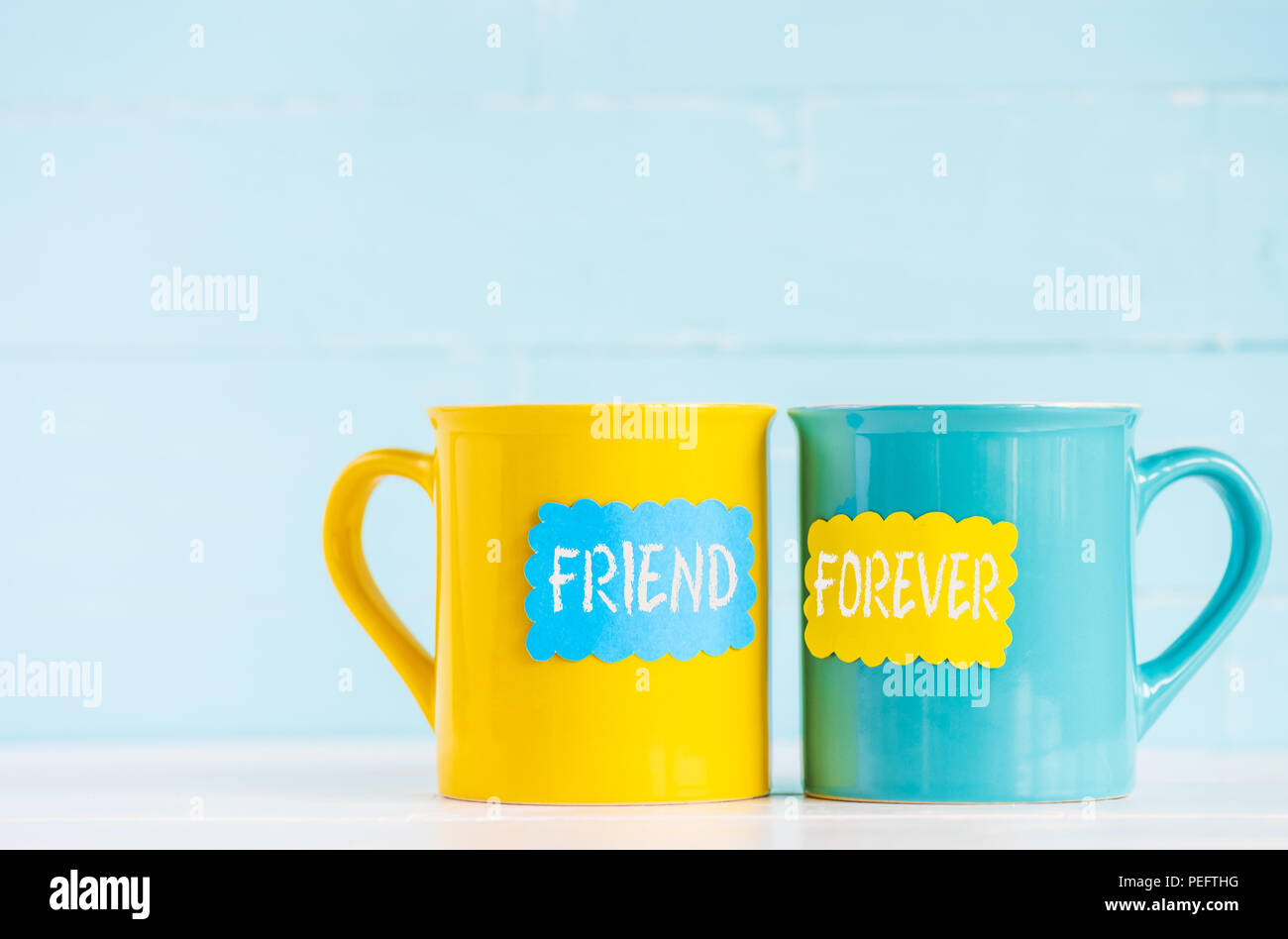 Tazze da caffè sul tavolo in legno con etichetta di carta e gli amici per sempre il testo. Amicizia day celebrazione sfondo Foto Stock