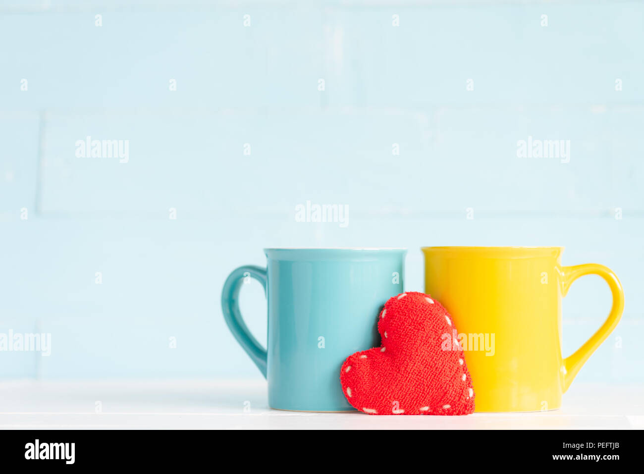 Tazze da caffè sul tavolo in legno fatti a mano con cuore rosso. Amicizia day celebrazione sfondo Foto Stock
