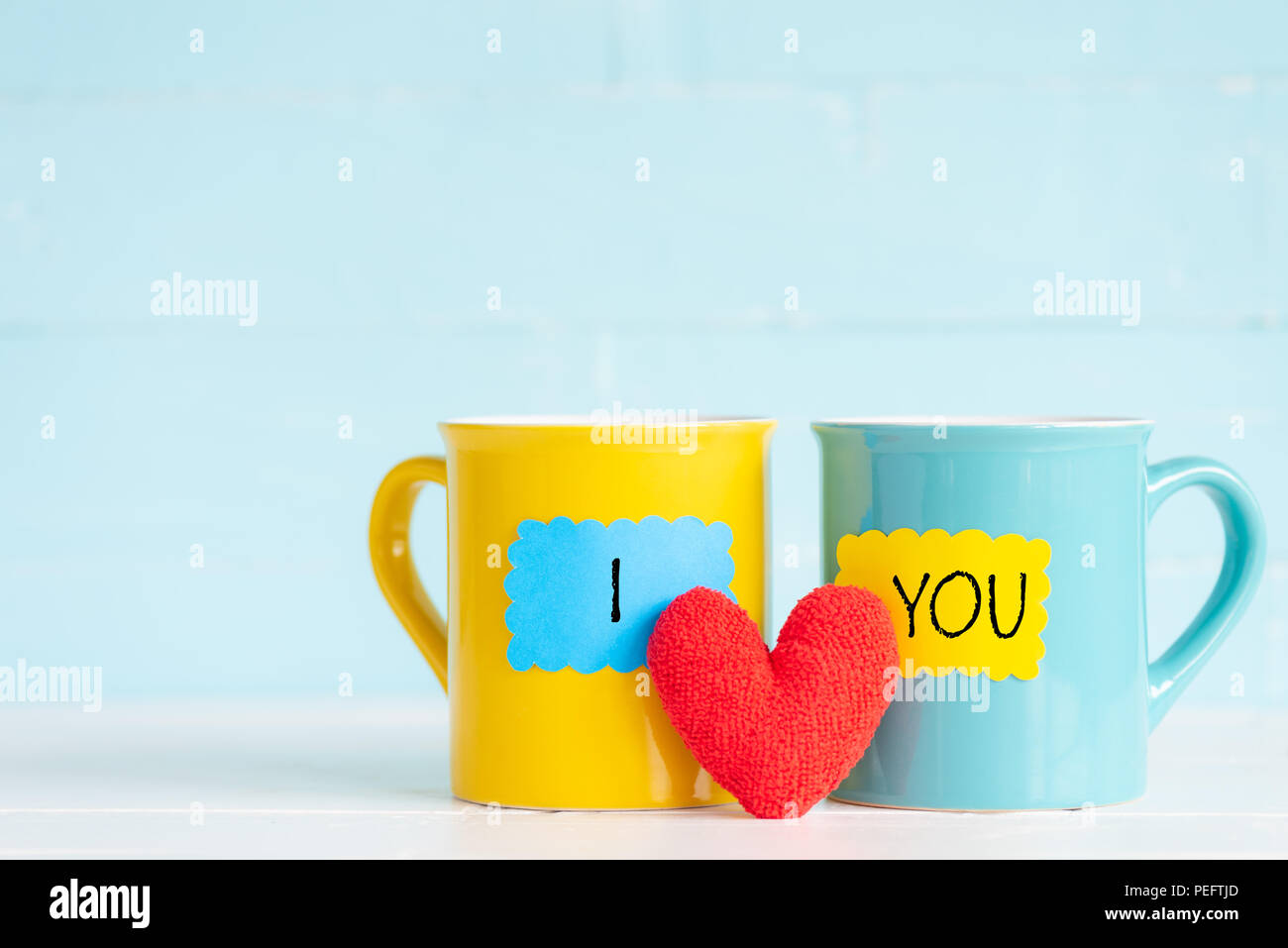 Tazze da caffè sul tavolo in legno con TI AMO testo e artigianale di cuore rosso. Amicizia day celebrazione sfondo Foto Stock