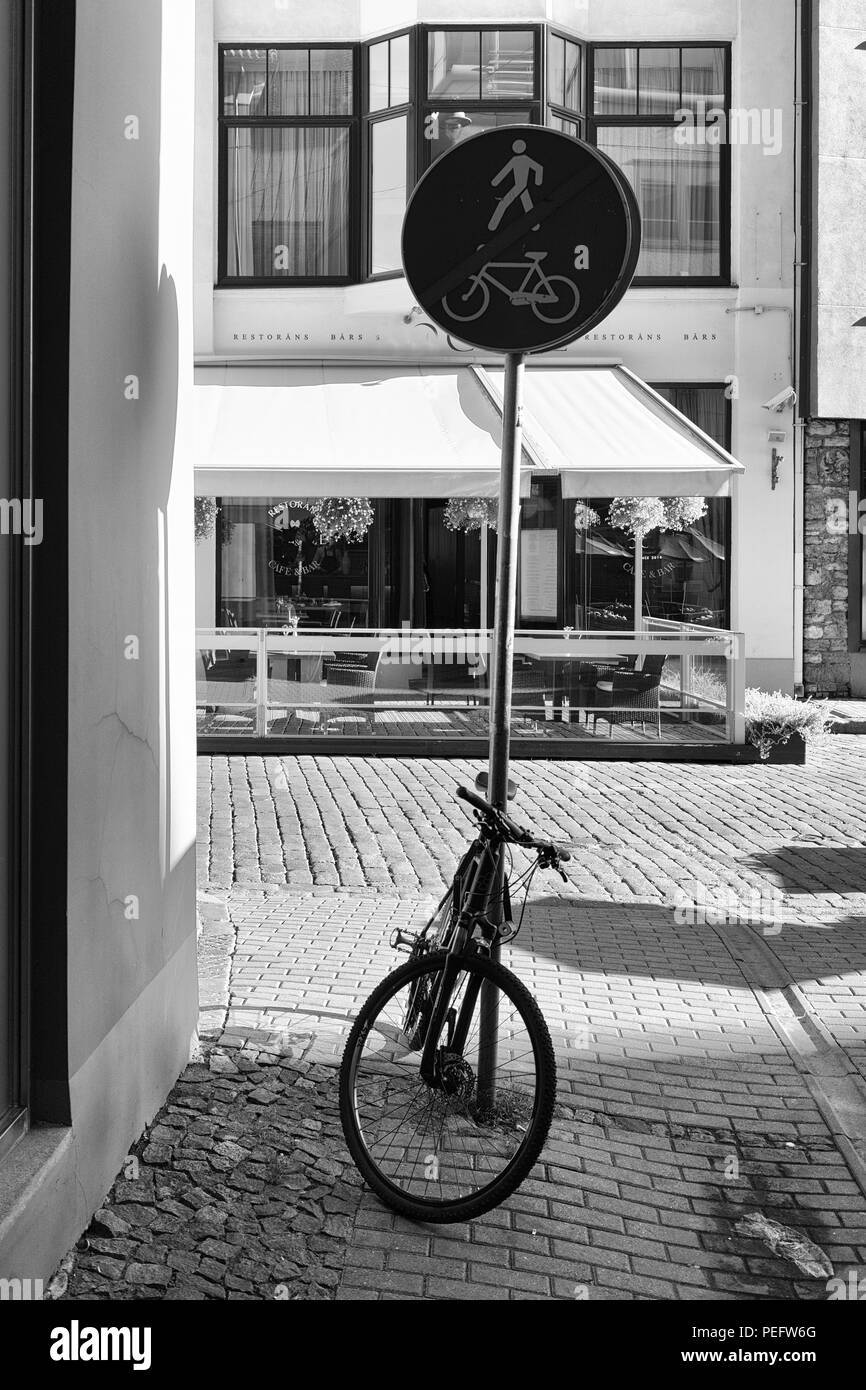 La Lettonia Riga. Bicicletta parcheggiata in zona pedonale fine segno sullo sfondo della terrazza estiva cafe Foto Stock