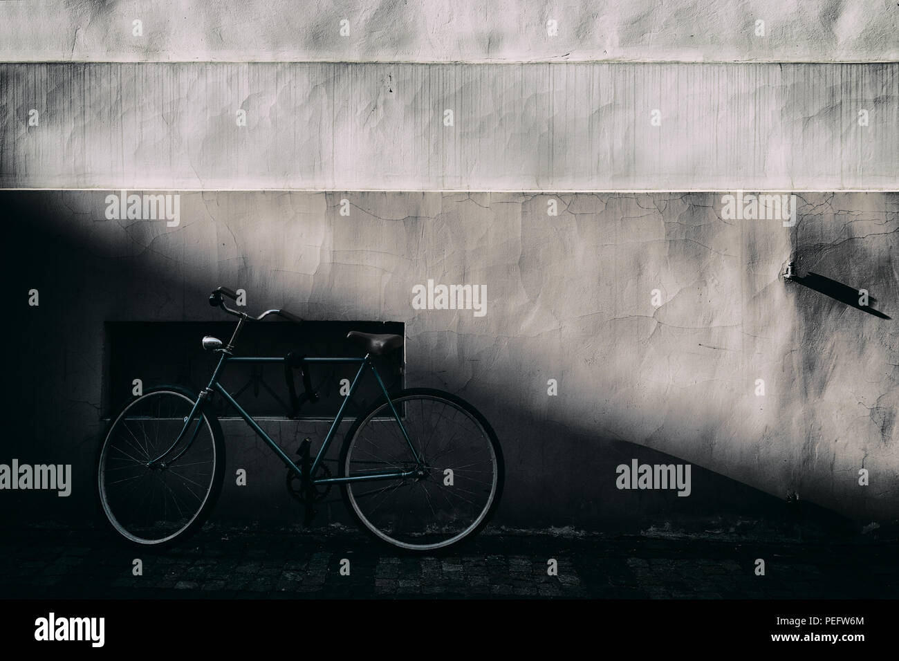 Bike sorge all'ombra del vecchio muro con un terreno in pendenza con una bella luce Foto Stock