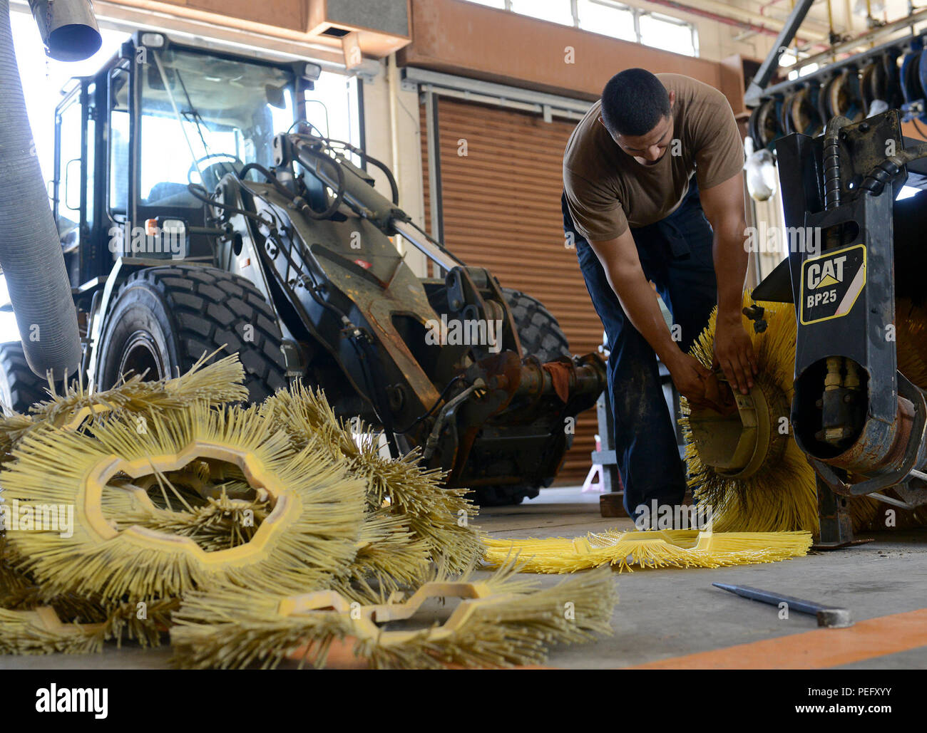 150813-N-SD120-007 Okinawa, in Giappone (8 agosto 2015) Costruzione meccanico Constructionman Christopher Miranda, da La Puente, California, attribuisce nuove spazzole ad una motospazzatrice allegato per caricatore in Naval Mobile Battaglione di costruzione (NMCB) 5's heavy officina. NMCB 5 è attualmente distribuito in Giappone e di alcuni paesi dell'area del Pacifico di operazioni condurre le operazioni di costruzione e di assistenza umanitaria progetti. (U.S. Foto di Marina di Massa lo specialista di comunicazione 1a classe John P. Curtis/rilasciato) Foto Stock