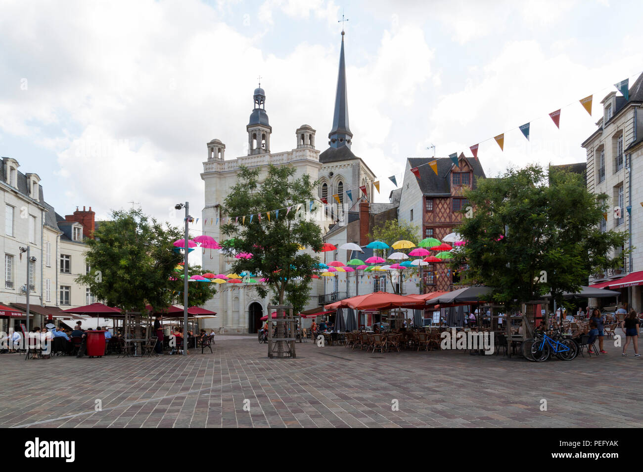 Saumur, Pays de la Loire, Francia - luglio 5, 2018: persone ristoranti e a piedi attraverso la trafficata piazza Place Saint-Pierre a Saumur con la Chiesa di San Pietro Foto Stock