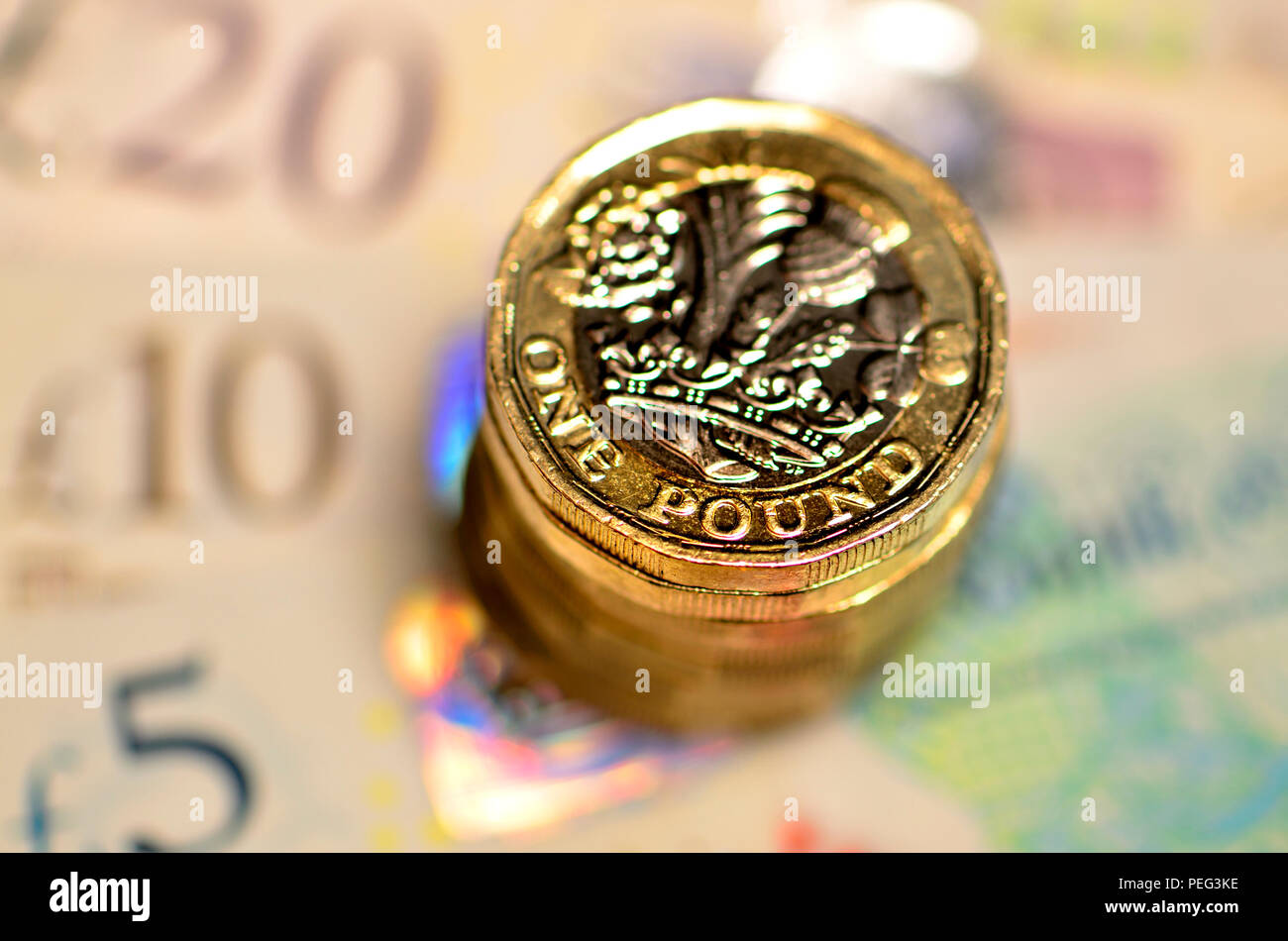 Pila di libbra di monete su British banconote Foto Stock