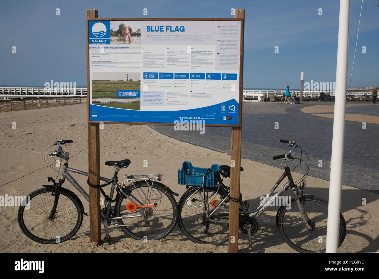 Spiaggia bandiera blu a Nieuwpoort-Bad con biciclette incatenato alla bacheca Foto Stock