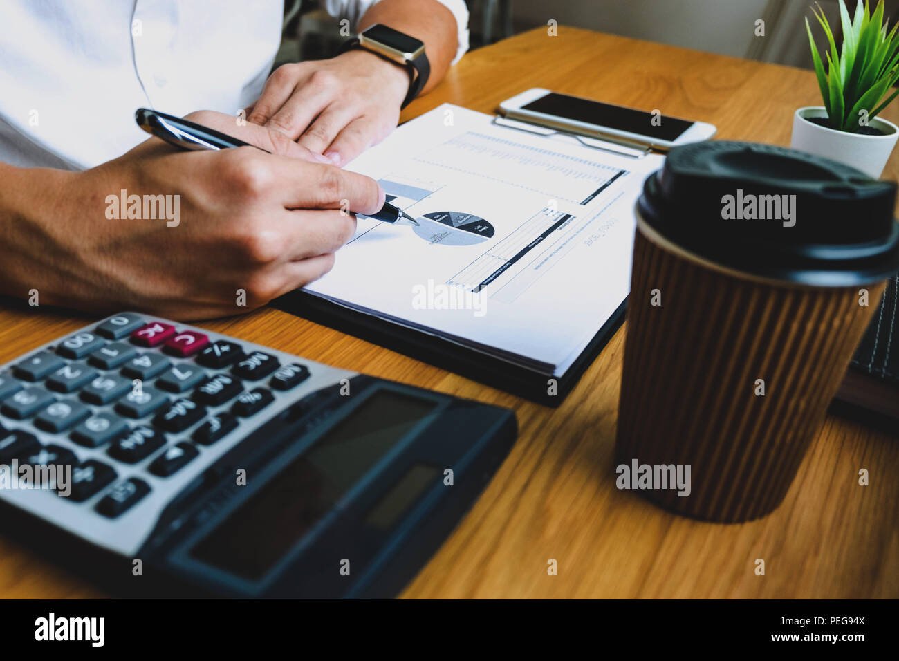 Imprenditori calcolare il reddito da attività di esportazione sul tavolo in legno.La concezione di business. Foto Stock