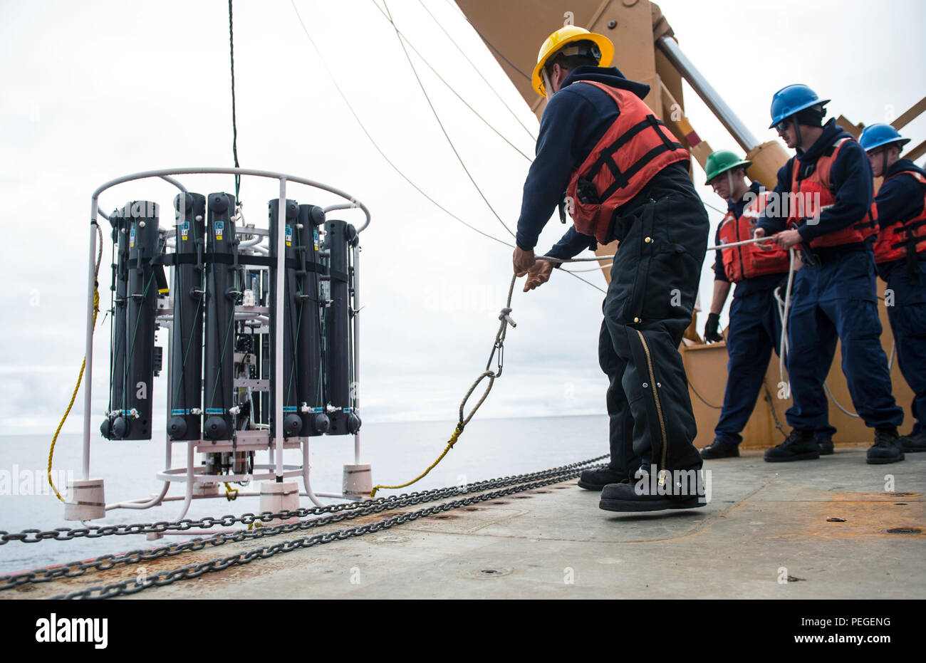 I membri dell'equipaggio a bordo di Guardacoste Healy lavoro per recuperare una rosetta CTD, un dispositivo progettato per raccogliere i campioni di acqua e di misurare le caratteristiche quali pressione, conducibilità e temperatura, mentre in corso il 10 agosto 2015, a sostegno della missione Geotraces. Geotraces è uno sforzo internazionale per studiare la distribuzione di elementi in tracce in oceani di tutto il mondo e per stabilire gli effetti di questi elementi sul cambiamento climatico globale. (U.S. Coast Guard foto di Sottufficiali di 2a classe di Cory J. Mendenhall) Foto Stock