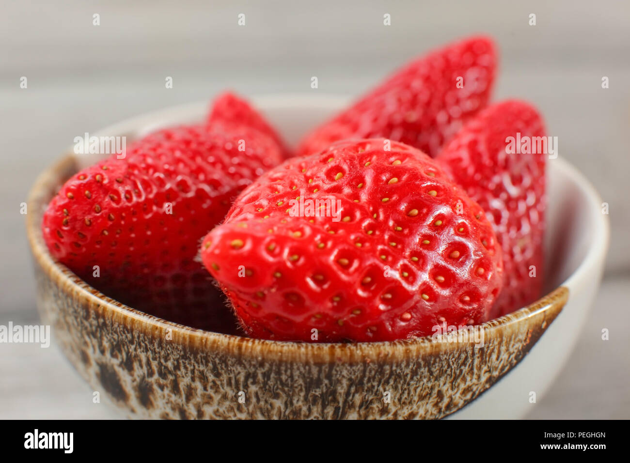 Una piccola ciotola di fragole, lascia rimosso. Foto Stock