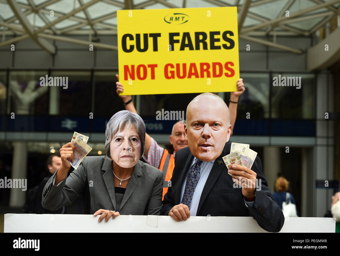 I membri del sindacato ferroviario, marittimo e dei trasporti (RMT) vestiti come primo ministro Theresa May e il segretario dei trasporti Chris Grayling prendono parte a una protesta sulle tariffe dei treni fuori dalla stazione di King's Cross a Londra. Foto Stock