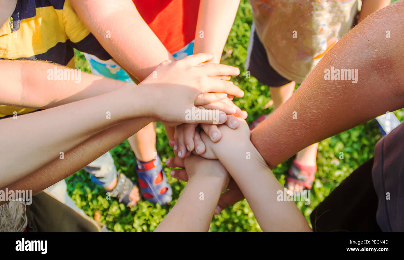 Mani di bambini, molti amici, giochi. Messa a fuoco selettiva estate Foto Stock