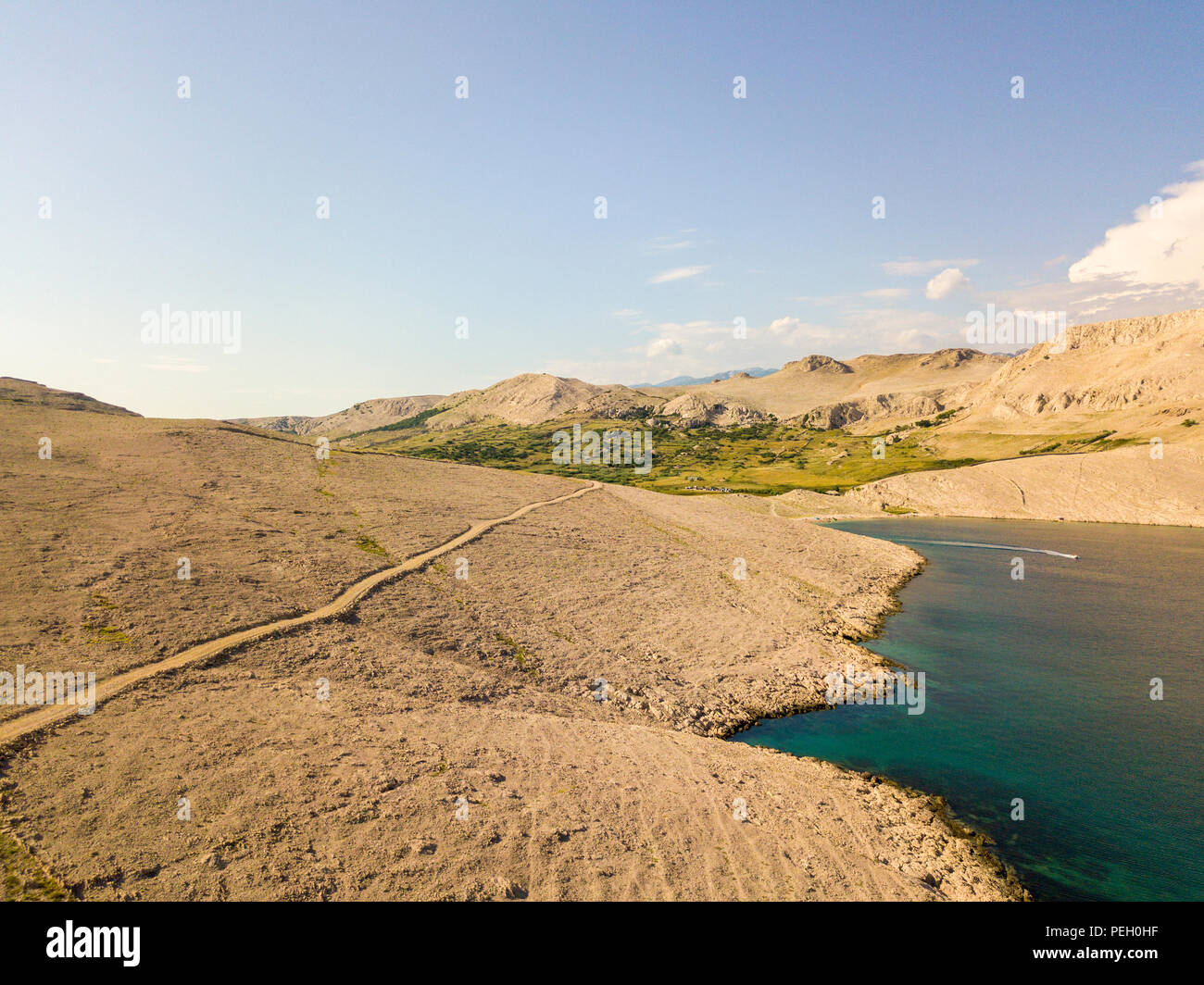 Vista aerea di una tortuosa strada che corre lungo le coste croate, sterrato, isola di Pag vicino Rucica beach a Metajna. Selvaggio e incontaminato Foto Stock