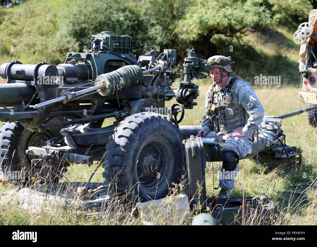 Stati Uniti Soldato assegnato al primo combattimento vigili del Team, ottantaduesima Airborne Division imposta un M119 Obice durante un giunto di ingresso forzato esercizio come più di mille paracadutisti da Germania, Italia, Paesi Bassi, Polonia, Regno Unito e Stati Uniti, ha condotto un'operazione aerea come parte di esercizio Risposta rapida 15 su Hohenburg drop zone in Hohenfels, Germania, 26 agosto. 2015. Le forze che lavorano insieme per raccogliere le attrezzature look per i feriti e di lasciare la zona di caduta per più ponticelli. (U.S. Foto dell'esercito da Staff Sgt. Kwadwo Frimpong / rilasciato) Foto Stock