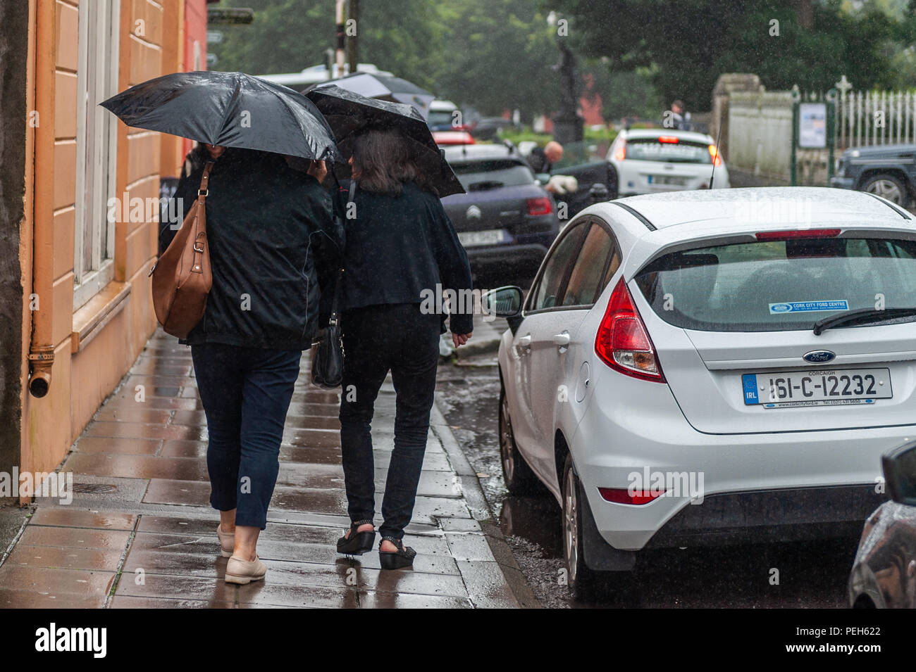 Clonakilty, West Cork, Irlanda. Il 15 agosto, 2018. Shoppers brave il tempo umido come la pioggia cade incessantemente in Clonakilty. Essa diventerà stasera dello scambiatore di calore con domani portando un mix di sunny incantesimi e docce sparse con alti di 19° Celsius. Credito: Andy Gibson/Alamy Live News. Foto Stock