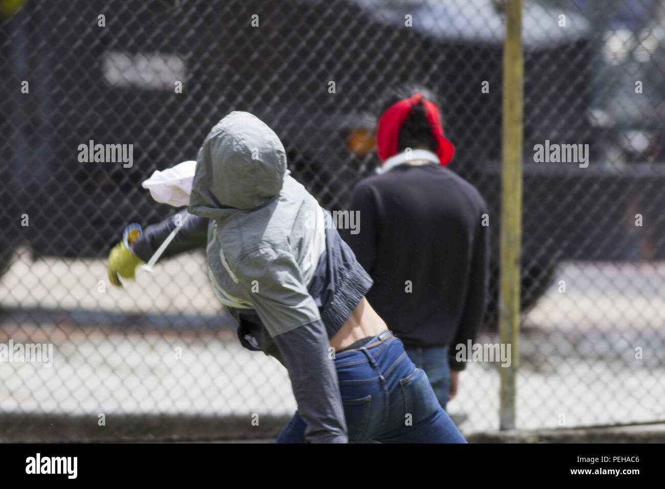 Incappucciati persone che lanciano pietre in scontri all'università nazionale della Colombia contro l'attuale governo del Presidente Ivan Duque. Il 15 agosto, 2018. Credito: Daniel Garzon Herazo/ZUMA filo/Alamy Live News Foto Stock