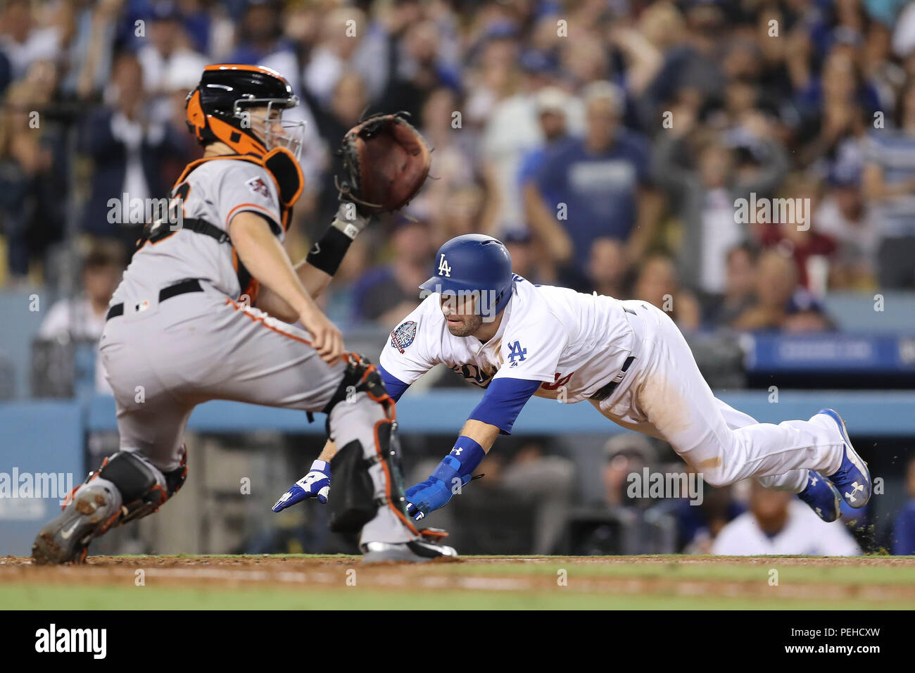 Los Angeles, Stati Uniti d'America. Agosto 15, 2018: Los Angeles Dodgers infielder Brian più dozier (6) scorre testa prima in casa la piastra come San Francisco Giants catcher Buster Posey (28) attende per il lancio del gioco tra i San Francisco Giants e il Los Angeles Dodgers, il Dodger Stadium di Los Angeles, CA. Fotografo: Pietro Joneleit. Credito: Cal Sport Media/Alamy Live News Foto Stock