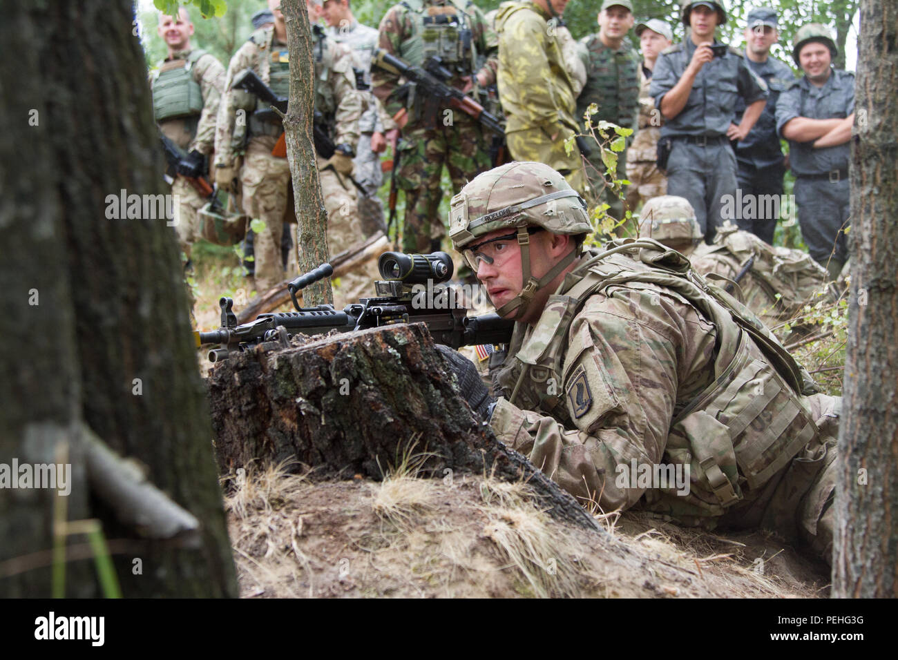 Pfc. Shane Roelofs, un paracadutista con gli Stati Uniti Dell'esercito 173rd Brigata Aerea, dimostra una posizione di tiro per la nazionale ucraina di soldati di guardia il Agosto 22, 2015, durante l intrepido custode in Yavoriv, Ucraina. Le guardie sono in conduzione squad live-formazione antincendio che si avvicinano alla fine del loro iterazione di intrepidi custode. Questa è la seconda delle tre rotazioni pianificate per il treno dell'Ucraina neo-costituita la guardia nazionale come parte di intrepida custode, programmata per durare fino a novembre. (U.S. Esercito foto di Sgt. Alexander Skripnichuk, xiii Affari pubblici distacco) Foto Stock