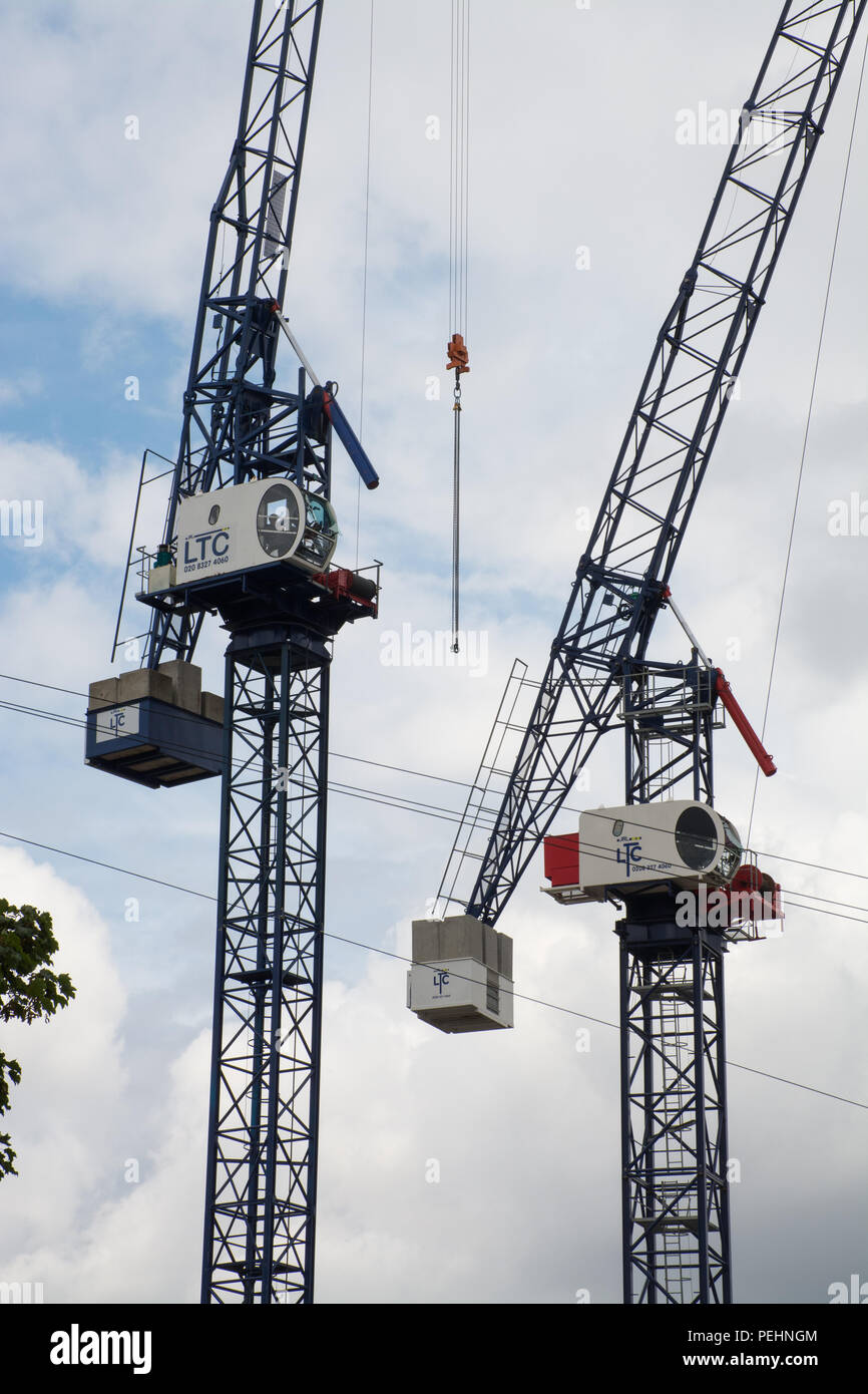 Una coppia di gru a torre su un sito di costruzione. Due gru a torre. Concetto di edilizia, sviluppo, lavori di costruzione Foto Stock