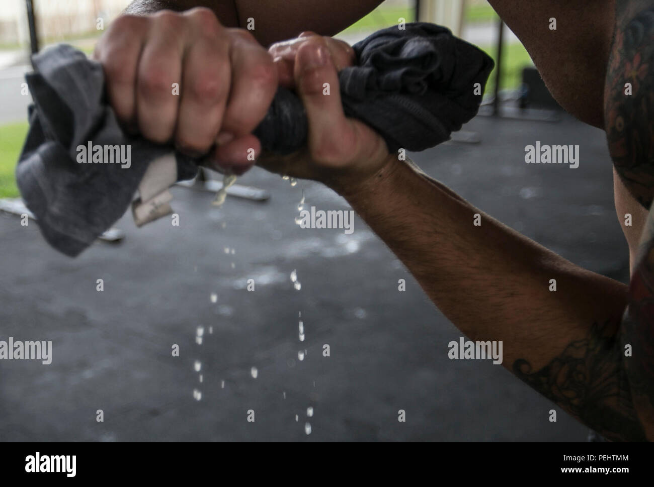 Sgt. Stephen Johnson wrings fuori il sudore dalla sua maglietta dopo un lungo allenamento il agosto 28 in Shogun CrossFit palestra a bordo di Kadena Air Base. A fianco di Master Sgt. Il Ciad Kiehl, Johnson treni quattro volte a settimana in preparati per il CrossFit giochi la prossima estate. "(Keihl) è stato il partner perfetto per me quando sono arrivato qui", ha detto Johnson, un videografo di combattimento con telecamera di combattimento, G-3/5; operazioni, formazione e piani; Marine Corps Impianti Pacific-Marine Corps Base Camp Butler. "Egli veramente mi spinge ad allenarsi di più e più in treno". Foto Stock