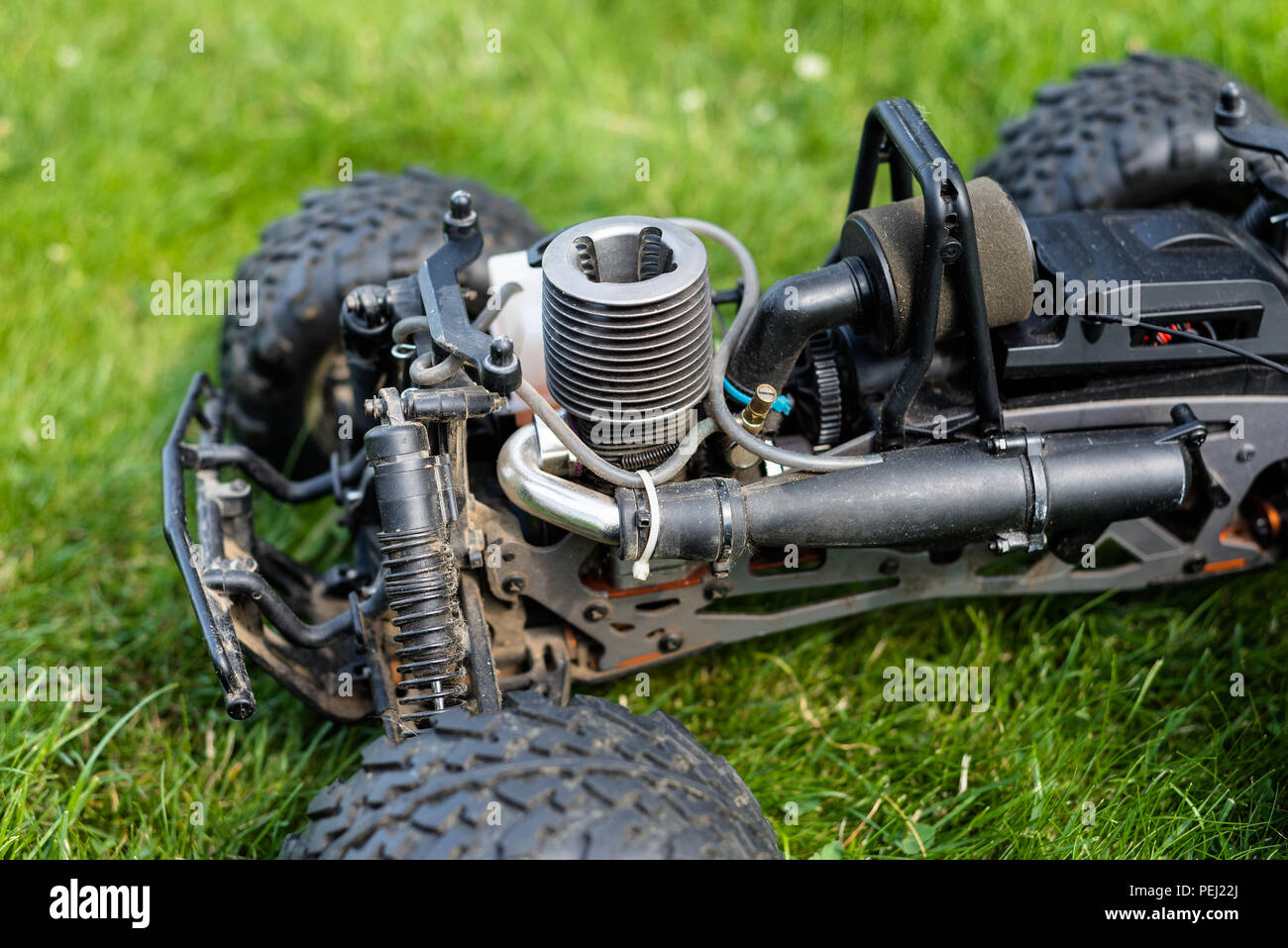 Radio-controllato ad auto con motore a combustione interna per il nitro carburante, con un cilindro, in piedi sul prato verde. Foto Stock