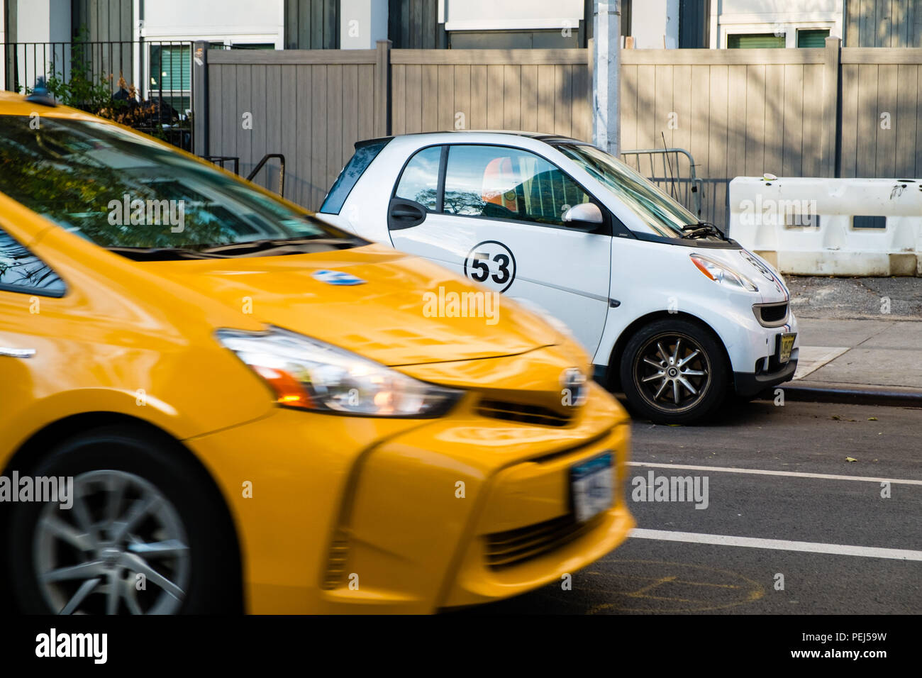 New York taxi giallo passando una Smart Auto con Herbie numero 53 la decalcomania Foto Stock