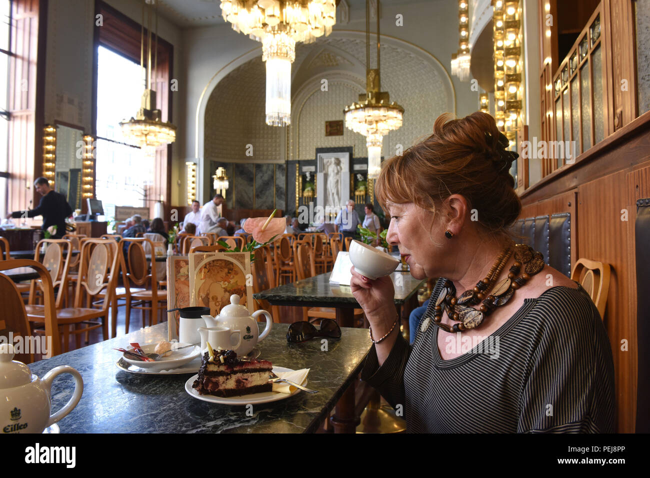 Signora donna turistica prendendo il tè pomeridiano e dolci presso la Praga Casa Municipale Repubblica Ceca Foto Stock