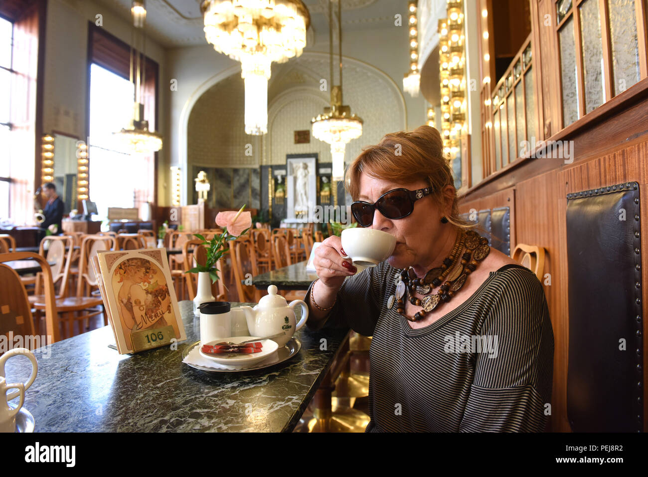Signora donna turistica prendendo il tè pomeridiano e dolci presso la Praga Casa Municipale Repubblica Ceca Foto Stock