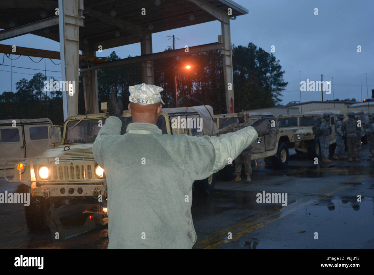 Sgt. 1. Classe Onsbey Presley, assegnato alla sede centrale e sede società, truppe speciali battaglione, terza divisione di fanteria supporto brigata, dirige un Humvee conducente indietro per impostare il carrello in linea per un battaglione rollout a Fort Stewart, Ga., 7 dicembre. Foto Stock