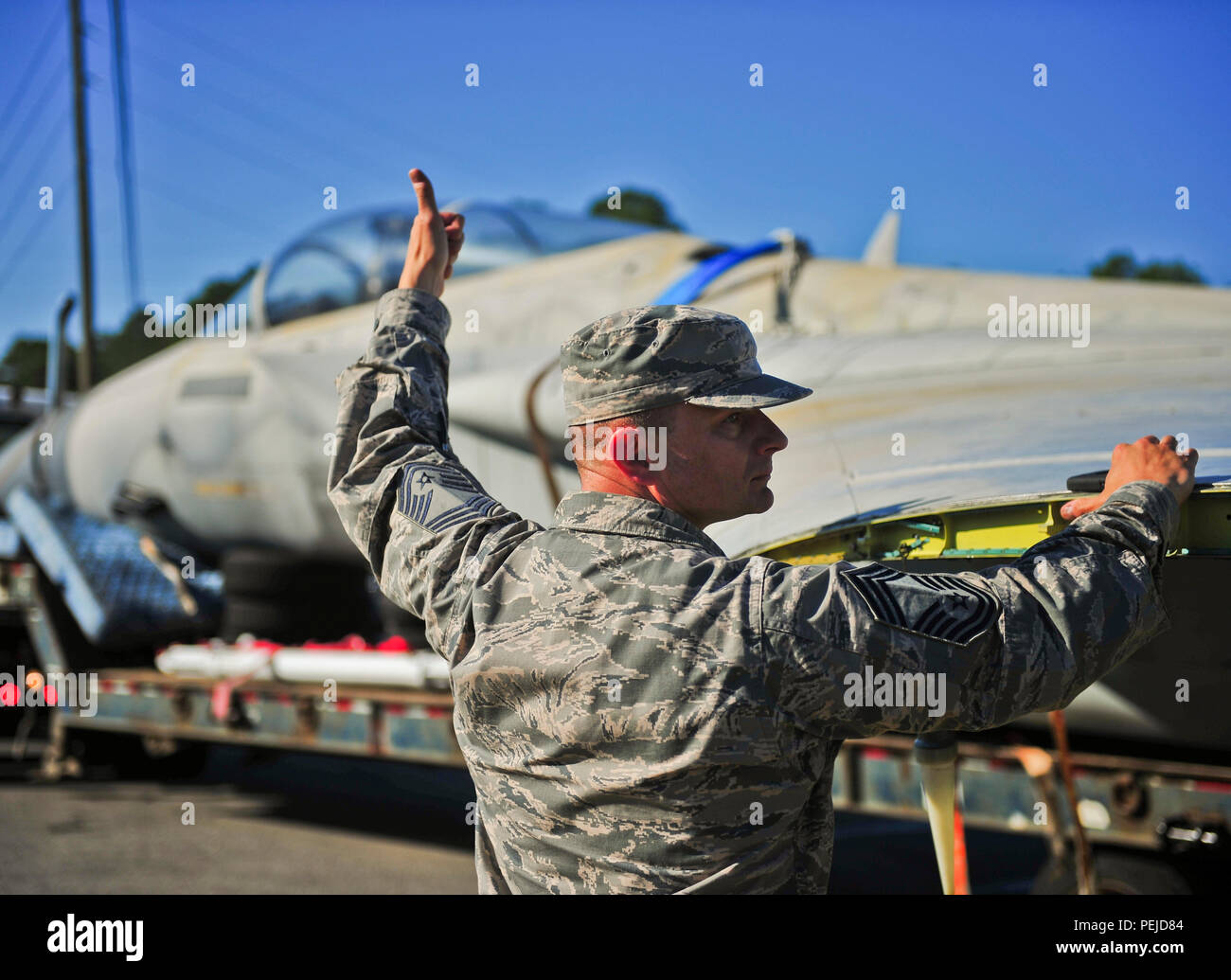 Master Chief Sgt. Gregorio Fenger, 325gruppo Manutenzione chief, assiste un pianale semi-camionista back up durante il trasporto di un F-15C Eagle Agosto 30. F-15C è stato usato come un terreno di formazione per istruttore di aeromobili per aviatori formazione per diventare F-15C equipaggio capi quando essi sono stati assegnati a Tyndall. (U.S. Air Force foto di Airman 1. Classe Dustin Mullen/rilasciato) Foto Stock