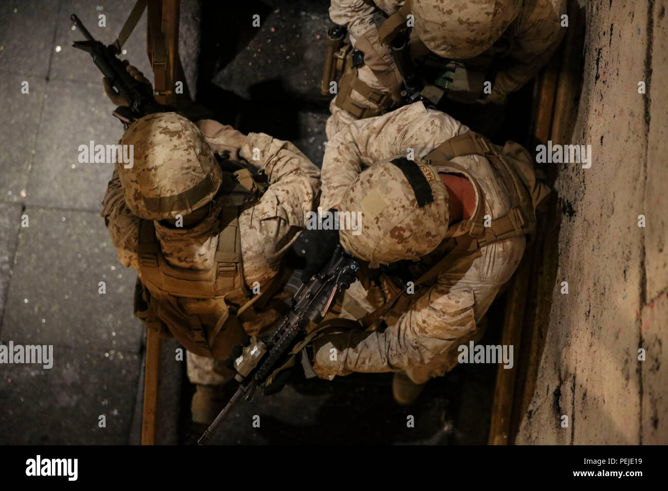 Un gruppo di Marines di spostarsi verso il basso di una rampa di scale in una casa di sparare a bordo della Northwest allegato durante Advanced Urban Combat Training Agosto 28. I corsi di formazione necessari i Marines a muoversi attraverso l'ambiente di formazione utilizzando le conoscenze che essi hanno dato a neutralizzare gli obiettivi che agisce come una minaccia. In aggiunta a questo, hanno anche utilizzato armi come flash bang granate così come vivere arrotonda facendo l'ambiente quanto più possibile realistica. I marines sono con Alfa flotta antiterrorismo Security Team Azienda. Foto Stock