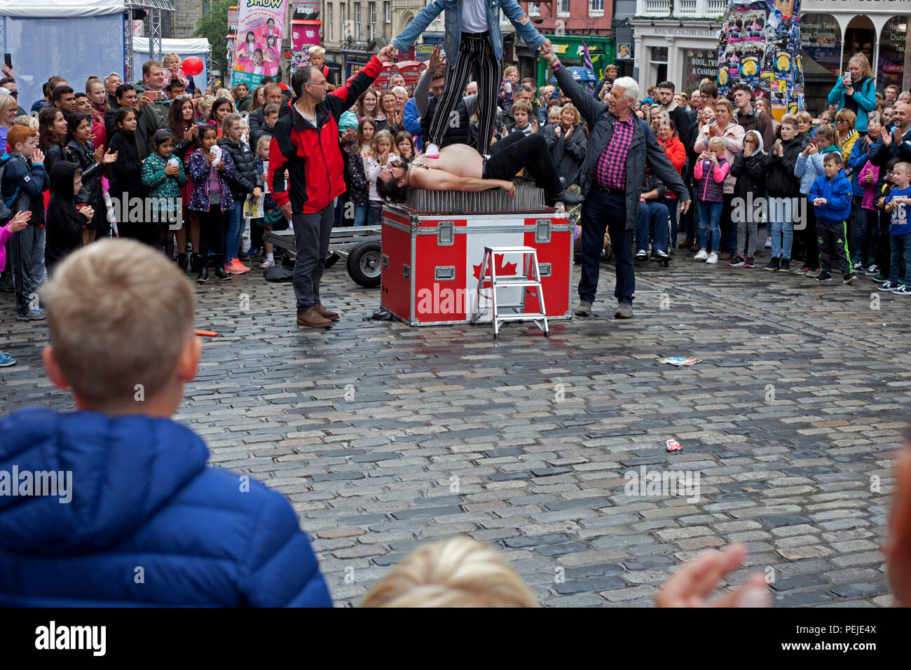 Edinburgh Fringe Festival Royal Mile di Edimburgo, Street performer giace sul letto di chiodi Scotland Regno Unito Foto Stock
