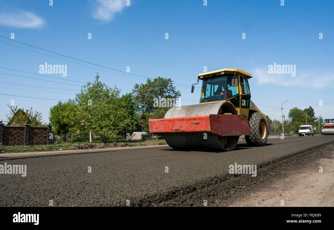 Pesante vibrazione rullo in corrispondenza di asfalto al lavoro sulla nuova strada sito in costruzione. La riparazione Foto Stock