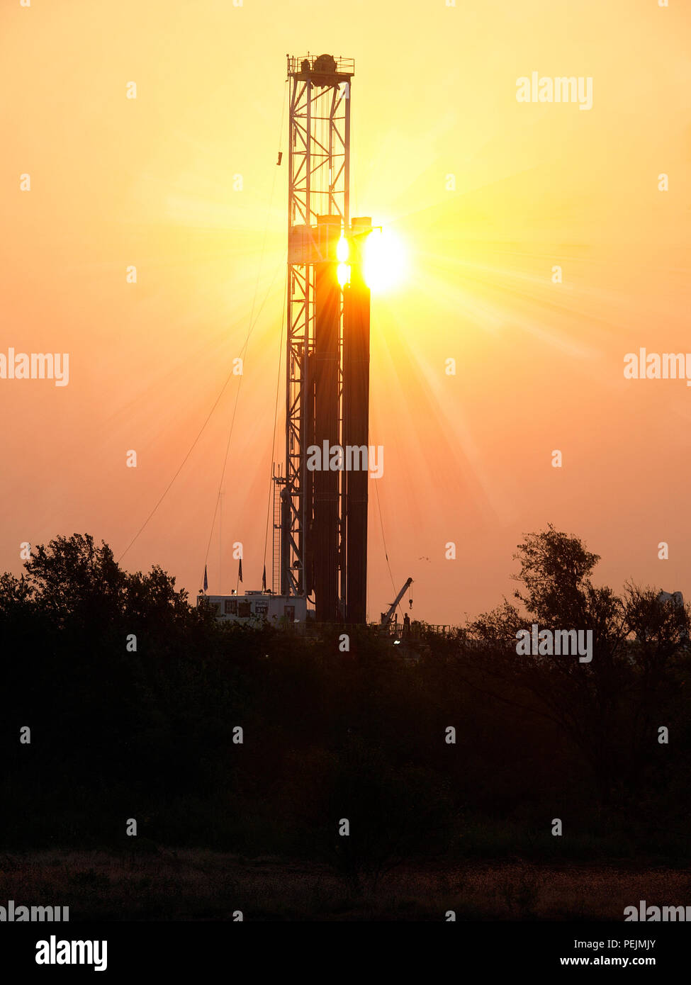 Sole sorge su un pozzetto di petrolio, prese nel nord Texas in Barnett Shale campo. Combustibile fossile è una crescente crisi come il mondo rifiuta di rallentare. Foto Stock