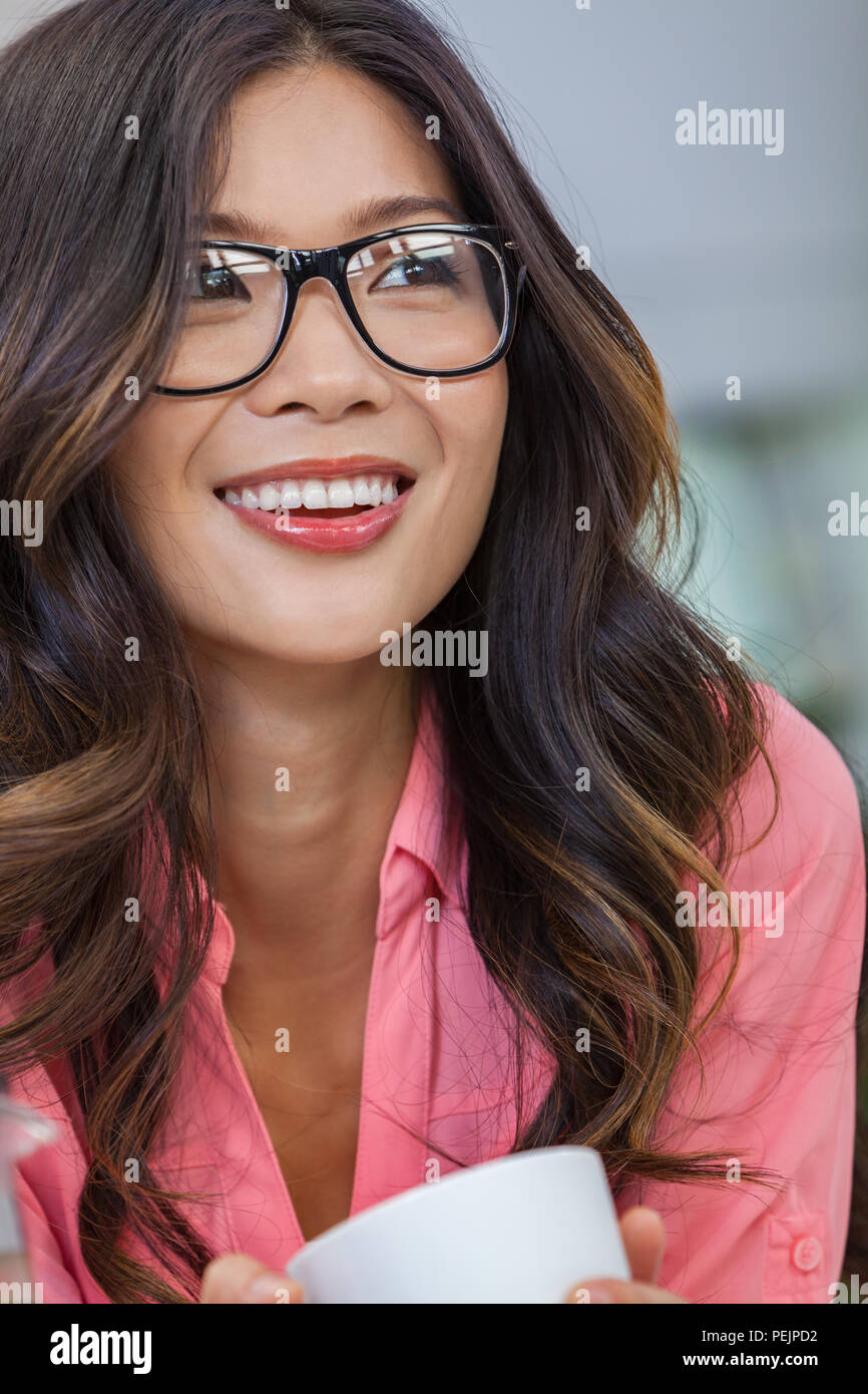 Bellissima giovane cinese asiatica donna o ragazza con gli occhiali sorridente e bere una tazza o tazza di caffè Foto Stock