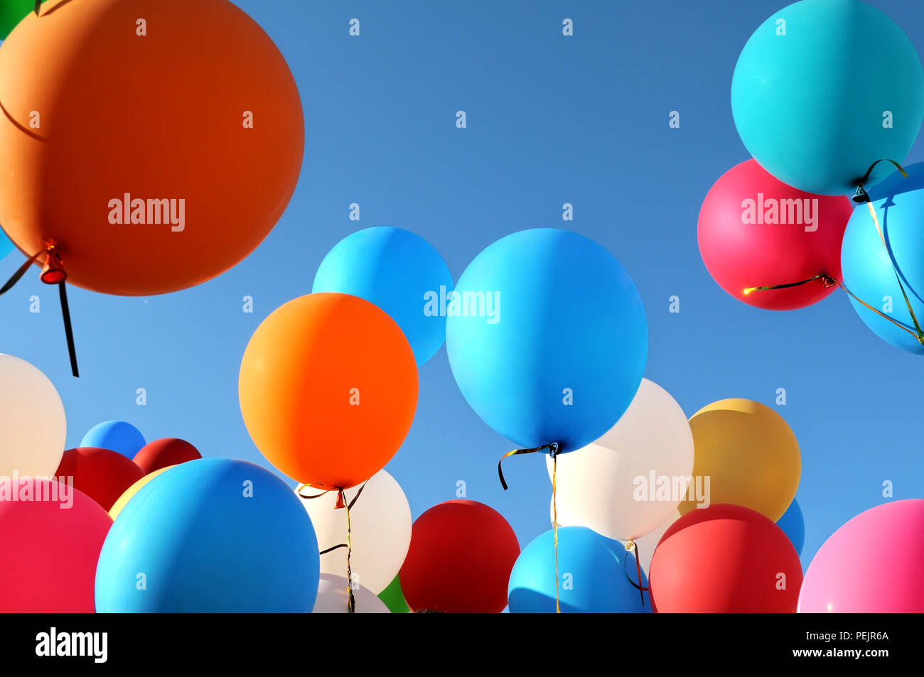 Palloncini multicolori nella città festival sul cielo blu sullo sfondo Foto Stock