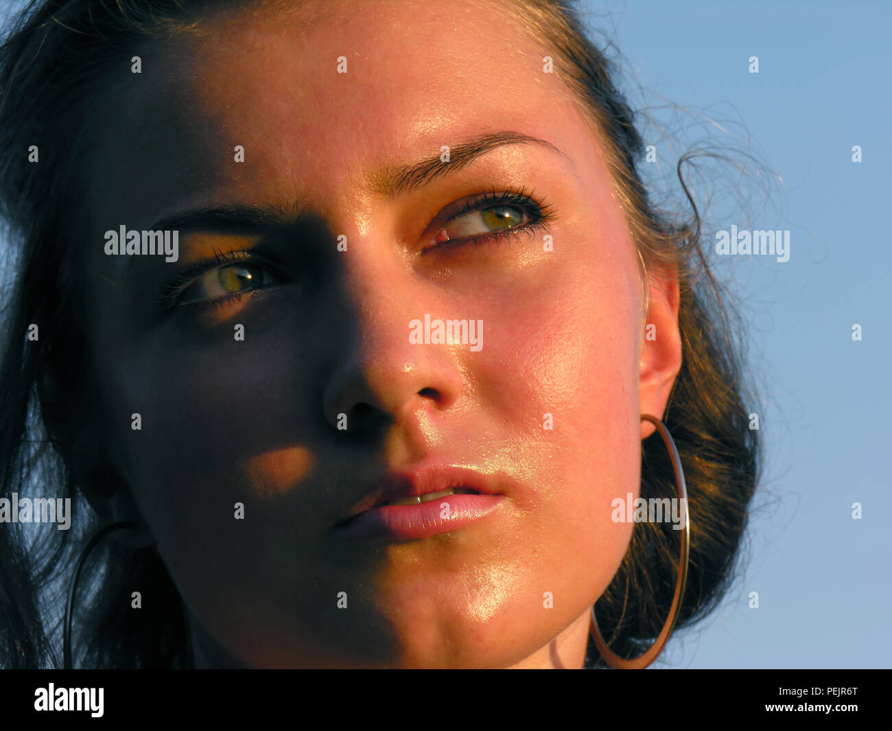 Close-up ritratto di Giovane fortemente donna bruciata dal sole nella stagione calda, luce della sera Foto Stock