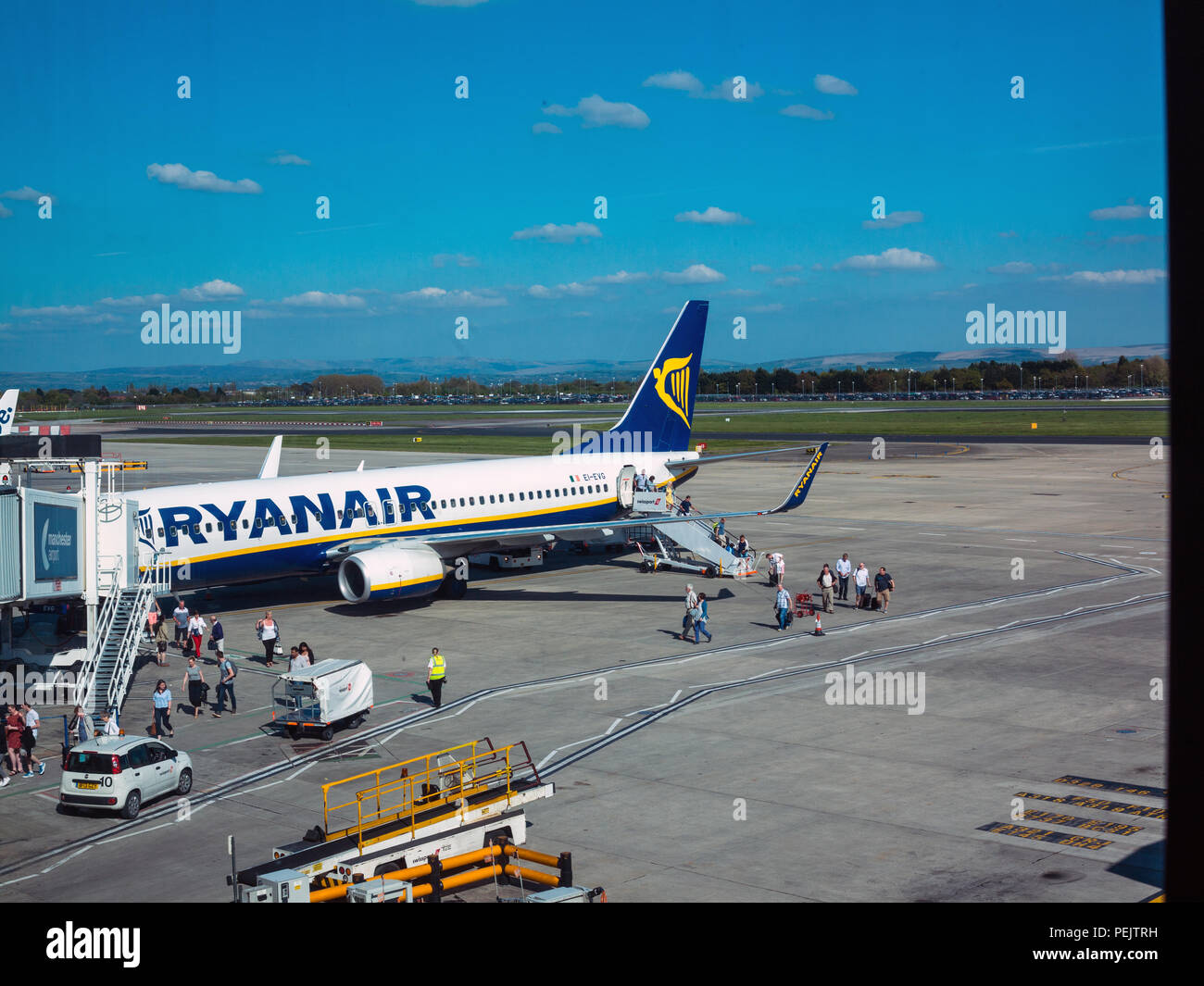 Passeggeri di scendere e salire a bordo di una compagnia aerea di bilancio di volo da Ryanair sulla pista dell'aeroporto di Manchester Inghilterra England Regno Unito Foto Stock