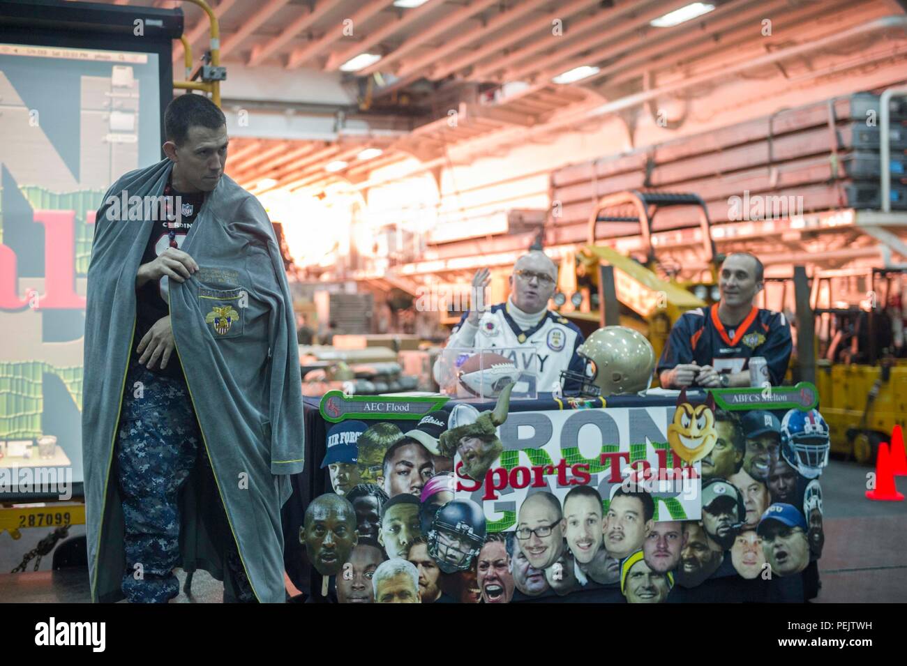 Oceano Pacifico (dec. n. 12, 2015) Ferro Gator Sports Talk host aviazione capo elettricista in Mate Matt modelli di esondazione a West Point "BATTERE ESERCITO" accappatoio come Capt. Clint Carroll, Commander, anfibio gruppo pronto (CPR) 3 e mostrano il co-host Senior Chief aviazione di Boatswain Mate (combustibili) Justin Melton discutere di come l'accappatoio si è verificato un ricamo a bordo Wasp-classe assalto anfibio nave USS Essex (LHD 2) durante una crociera di Tiger. L'Essex è il prodotto di punta della Essex anfibio gruppo pronto e, con l'avviato xv Marine Expeditionary Unit (XV MEU), è attualmente operanti negli Stati Uniti La terza area della flotta di responsa Foto Stock