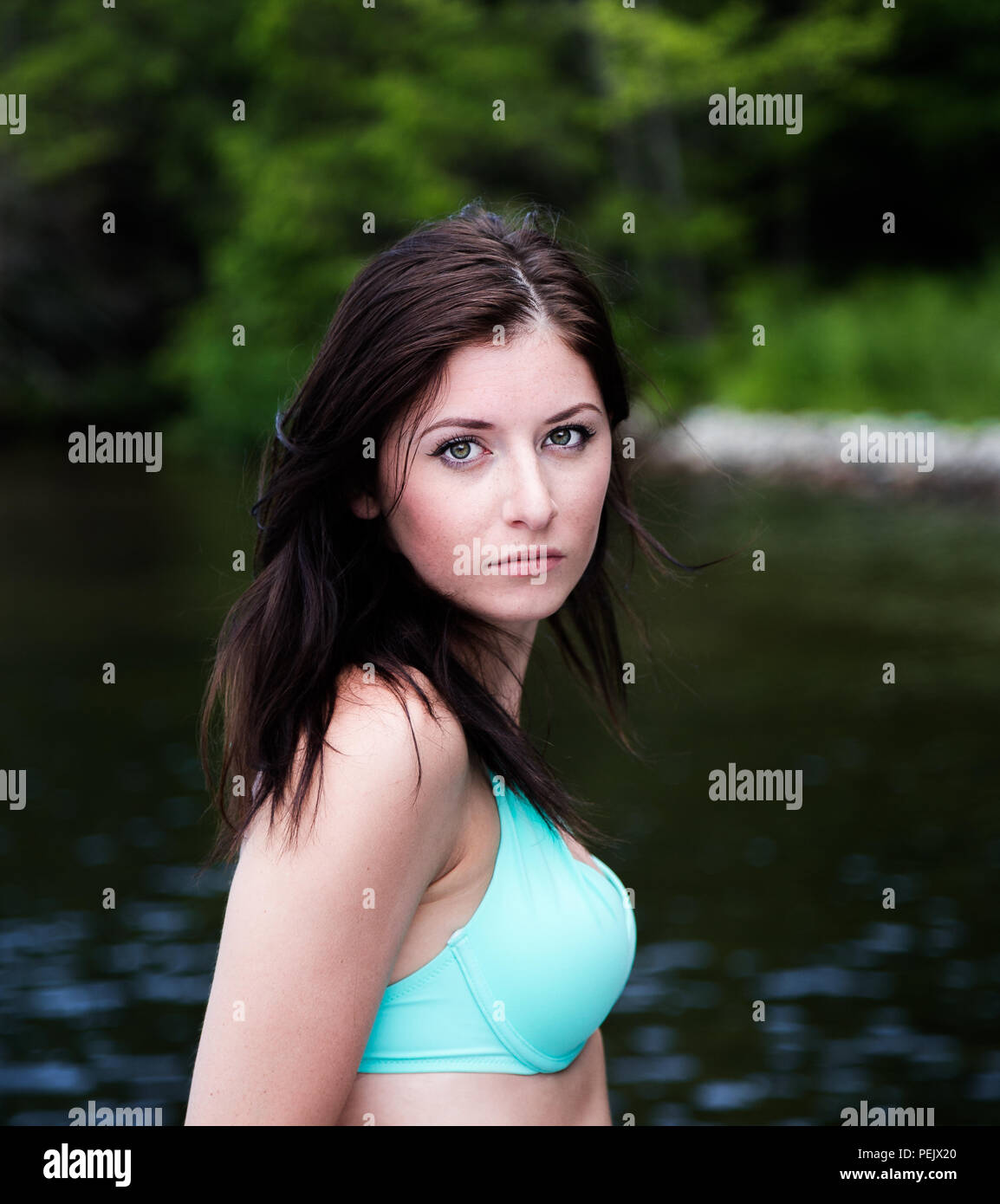 Ritratto di un bel giovane donna in posa di fronte a un lago. Foto Stock