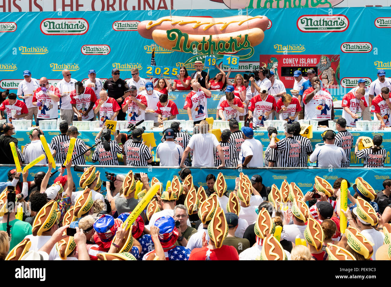 Joey Chestnut (centro, appena al di sotto dell uomo nel cappello di paglia e blazer blu) mangiato 74 hot dogs e panini in dieci minuti, un nuovo record del mondo per vincere la 2018 Na Foto Stock