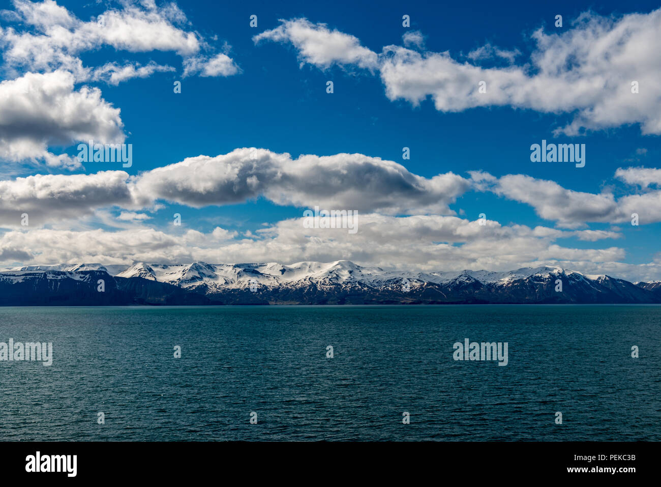 Paesaggio islandese con un grande corpo di acqua nella parte anteriore. Cielo blu e nuvole bianche in background Foto Stock