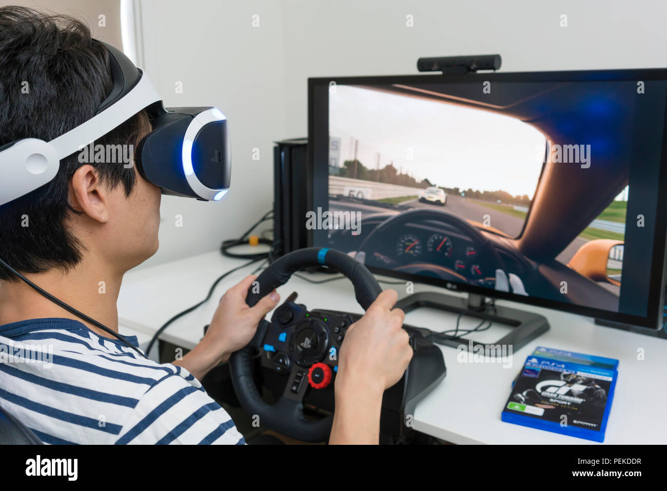 Riproduzione di video racing game con auricolare VR a casa Foto Stock