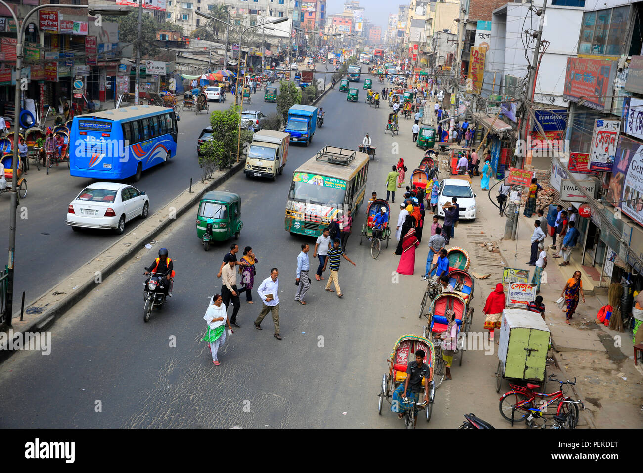 Pedoni attraversare una strada trafficata a rischio della vita. Dacca in Bangladesh Foto Stock