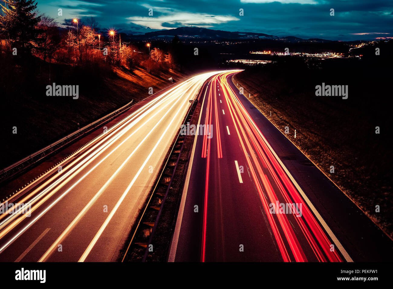 Una lunga esposizione night shot di una autostrada da regione di Friburgo in Svizzera con rosso luce del veicolo sentieri e luci di pubblico Foto Stock