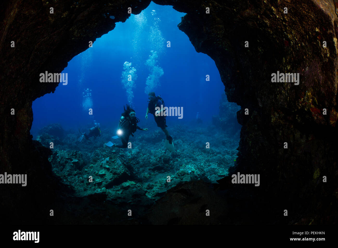 Divers (MR) raffigurato all'entrata di un tubo di lava fuori dell'isola di Lanai, Hawaii. Foto Stock
